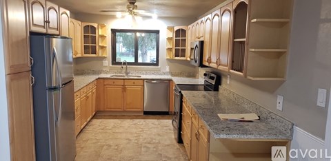 A kitchen with wooden cabinets and granite countertops.