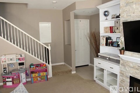 A living room with a fireplace and a television on the wall.