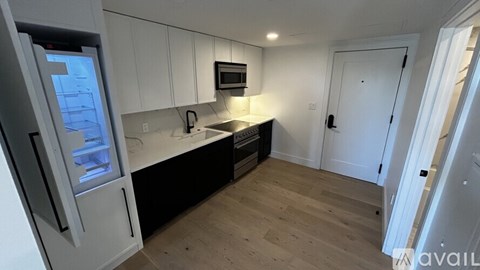 A kitchen with white cabinets and a black countertop.