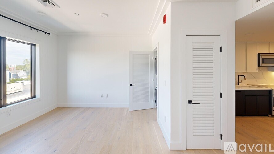 A spacious room with a door on the right and a window on the left.