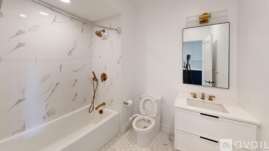 A bathroom with a white tub, toilet, and sink.