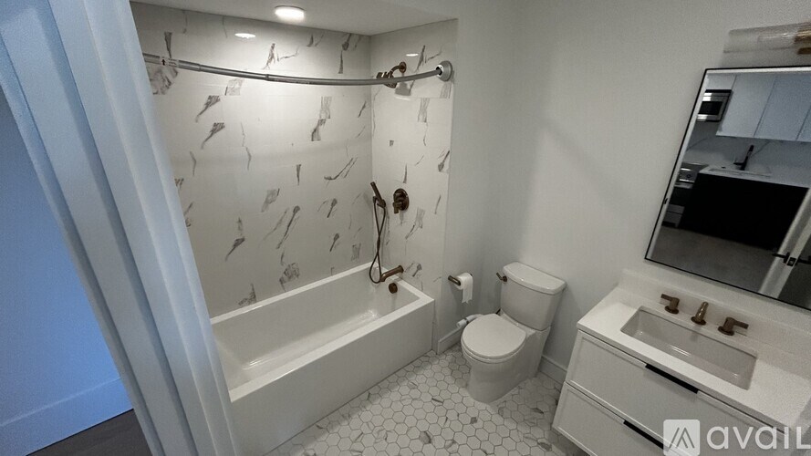 A bathroom with a white bathtub, toilet, and sink.