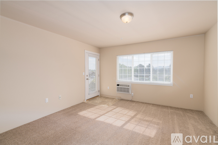 A spacious room with a window and a door.