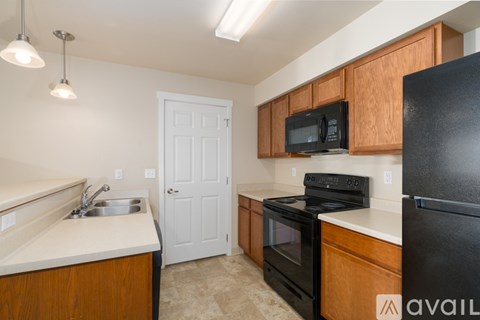 A kitchen with black appliances and wooden cabinets.