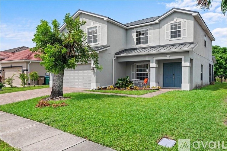 A two-story house with a garage and a tree in front.