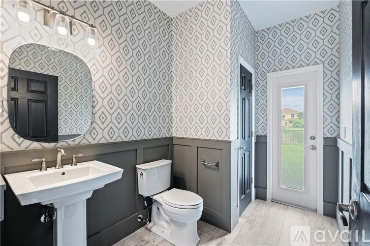 A bathroom with a toilet, sink, and a door.