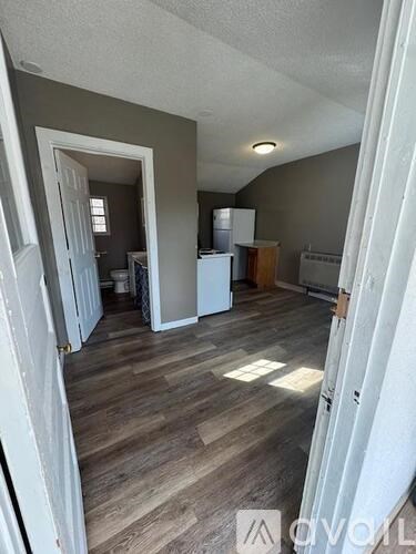 A room with wooden flooring and a white door.