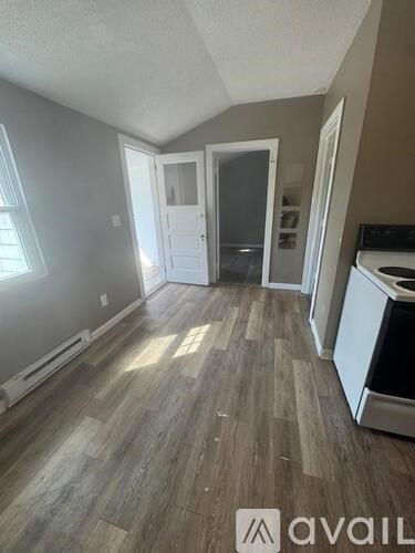 A room with wooden flooring and a white door.