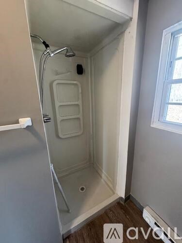 A small white bathroom with a walk in shower.