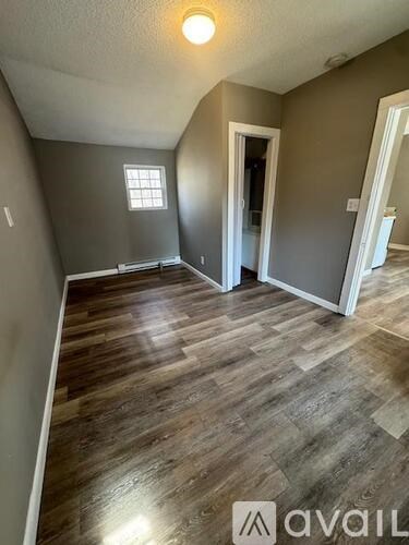 A room with wooden flooring and a window.