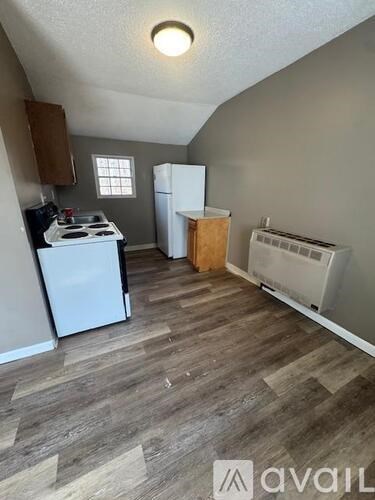 A kitchen area with a white stove and a white refrigerator.
