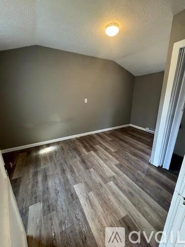 A room with wooden flooring and a white door.