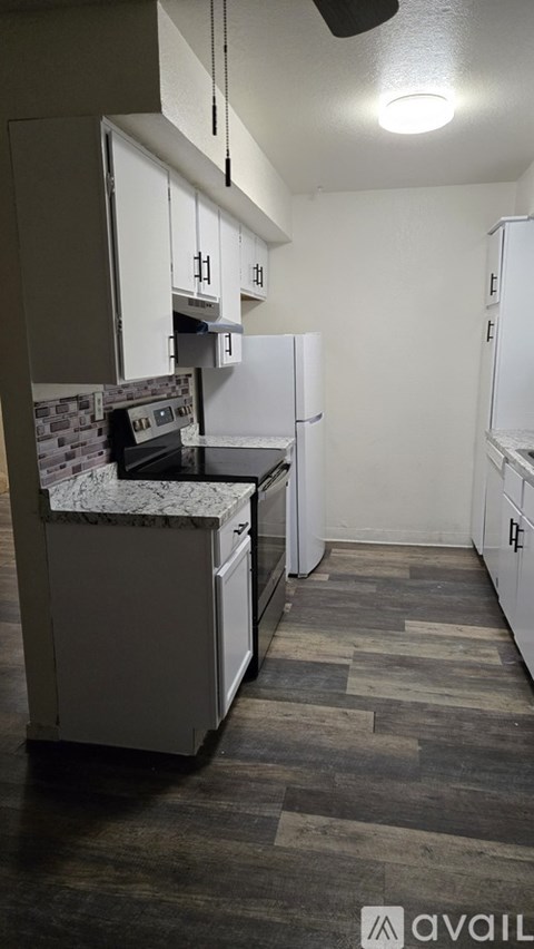 A kitchen with a white fridge and a white counter top.