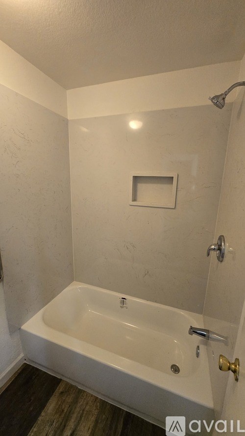 A white bathroom with a tub and a shower.