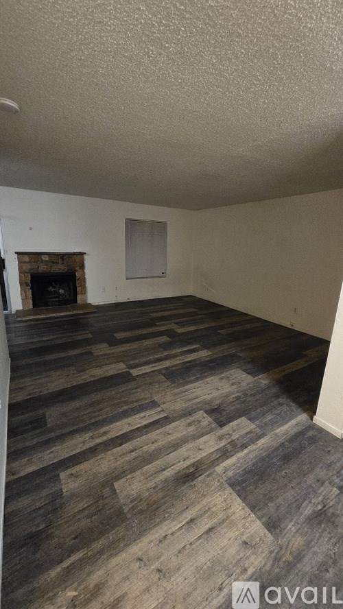 A room with a fireplace and wooden flooring.