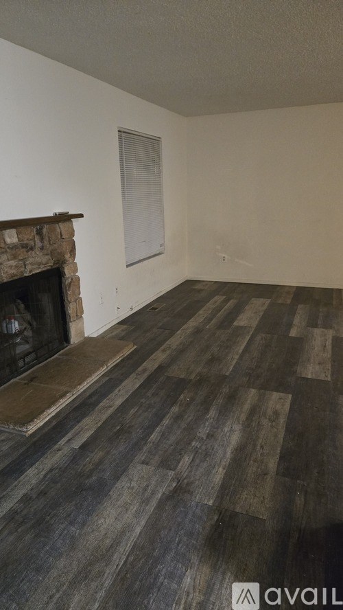 A room with a fireplace and wooden flooring.