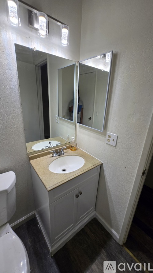 A bathroom with a sink, mirror, and toilet.