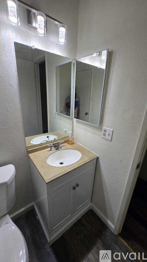 A bathroom with a sink, mirror, and toilet.