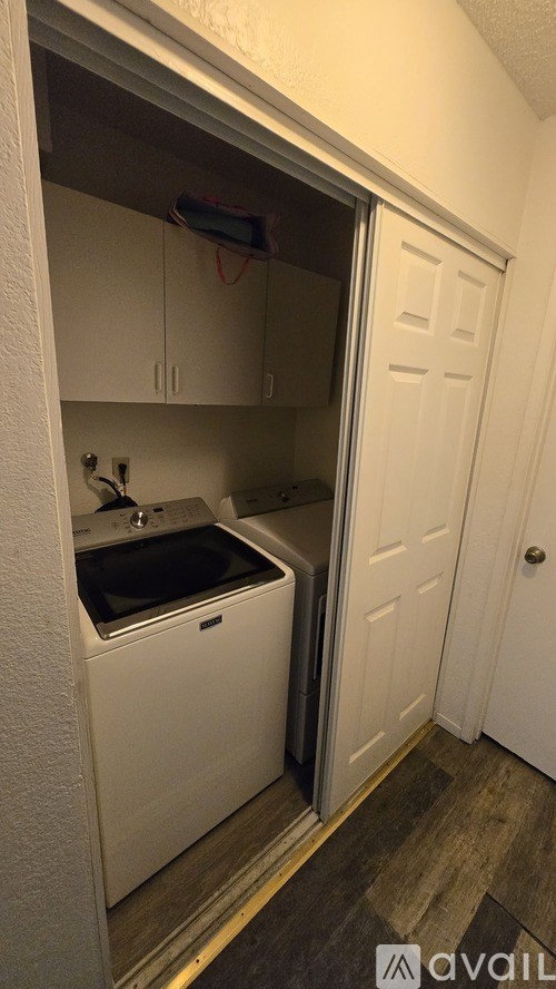 A small white washer and dryer in a laundry closet.