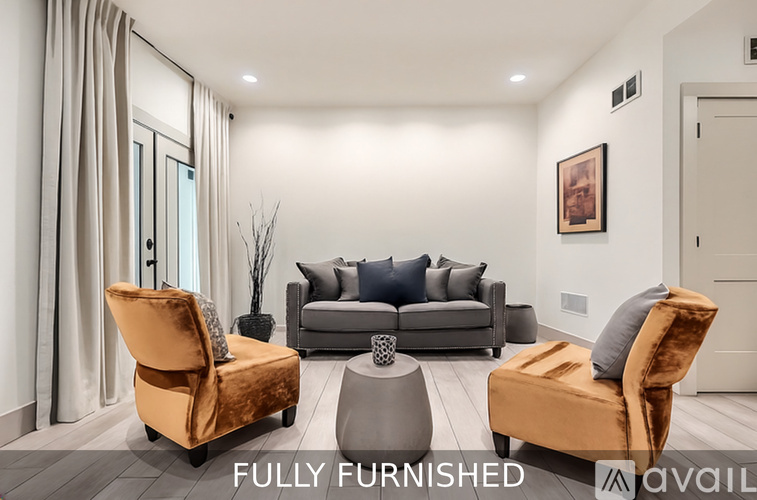 A fully furnished room with a sofa, two chairs, and a coffee table.