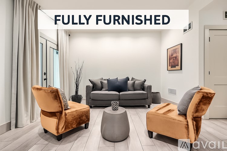 A fully furnished room with a sofa, two chairs, and a coffee table.