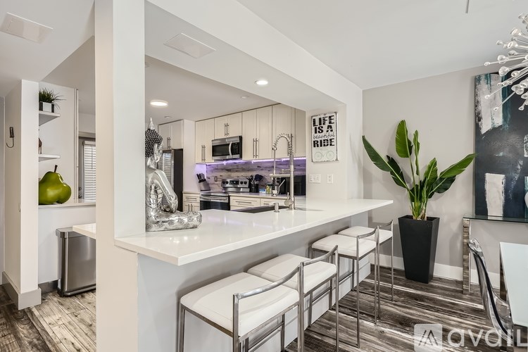A modern kitchen with a white countertop and a fridge.