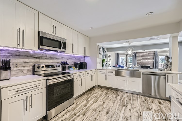 A modern kitchen with white cabinets and stainless steel appliances.