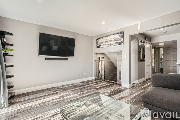A living room with a flat screen TV mounted on the wall.