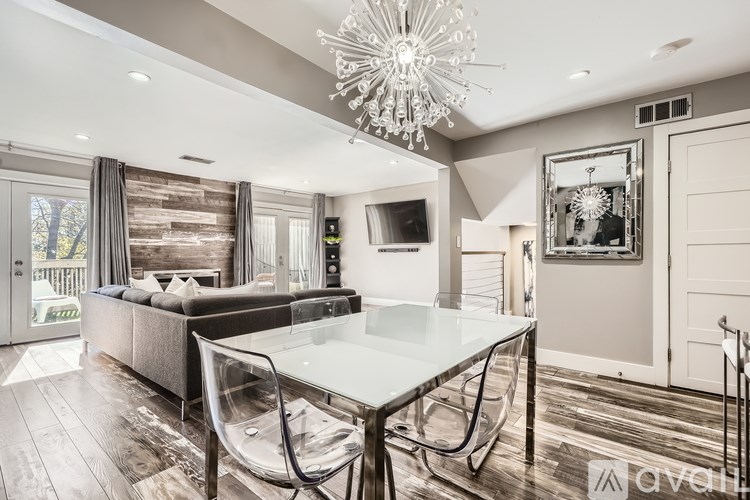 A modern dining room with a glass table and chairs.