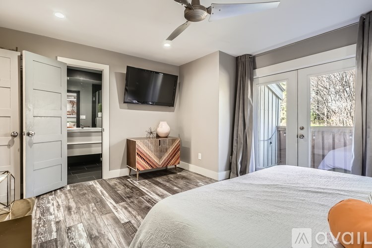 A bedroom with a large bed and a flat screen TV mounted on the wall.