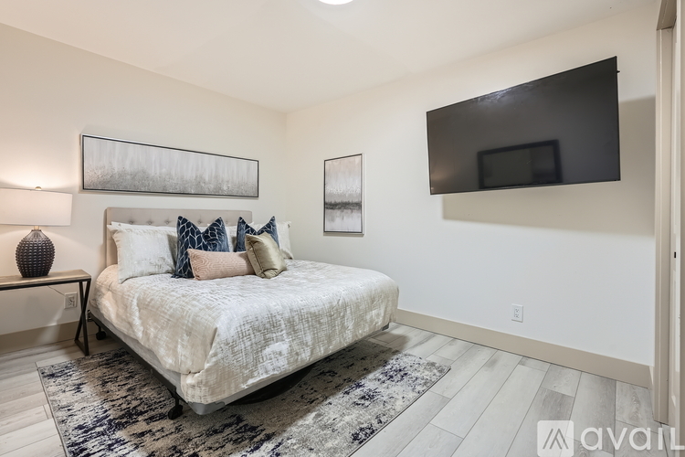 A bedroom with a large bed and a flat screen TV mounted on the wall.