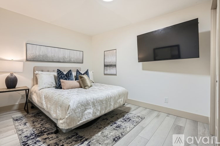 A bedroom with a large bed and a flat screen TV mounted on the wall.