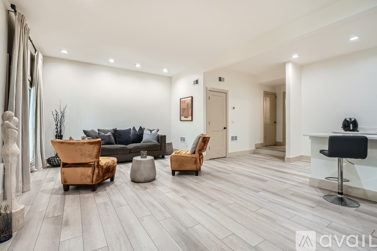 A living room with a couch, two chairs, and a table.