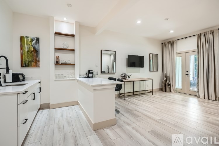 A modern kitchen with a breakfast bar and a large window.