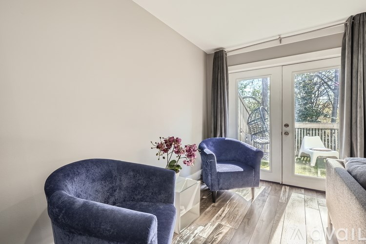 A living room with two chairs and a table with flowers on it.