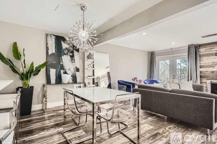 A modern living room with a glass dining table and chairs.