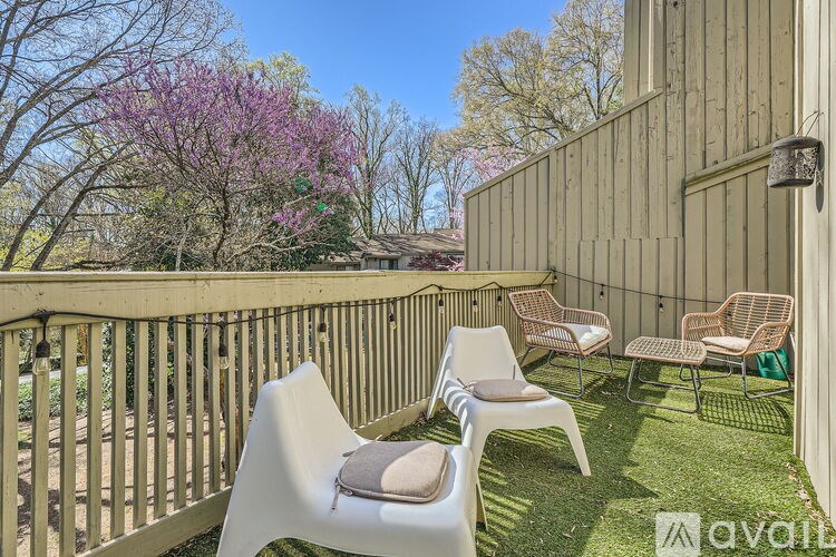 A patio with chairs and a fence.