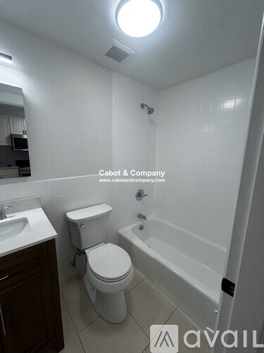 A white toilet and sink in a small bathroom.