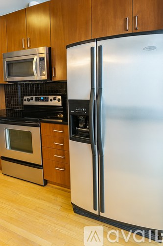 A kitchen with a stainless steel refrigerator and a microwave above the stove.