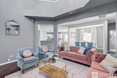 A living room with a pink sofa and blue chairs.