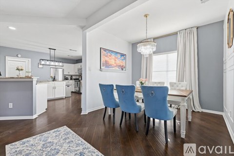 A dining room with a table and chairs.