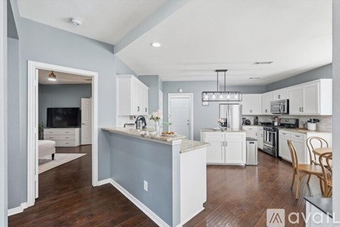A kitchen with white cabinets and a blue island.