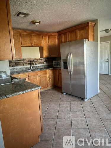 A kitchen with wooden cabinets and a granite countertop.