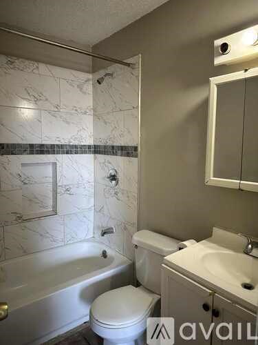 A bathroom with a toilet, sink, and bathtub.