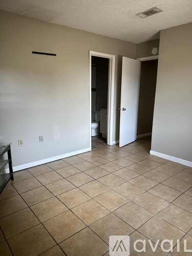 A room with tile flooring and a doorway leading to another room.