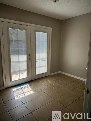 A room with a tiled floor and a sliding glass door.