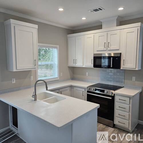 A kitchen with white appliances and cabinets.