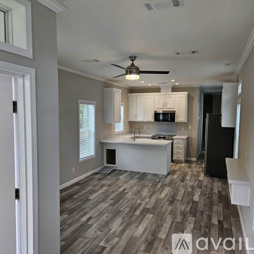 A room with wooden flooring and a ceiling fan.