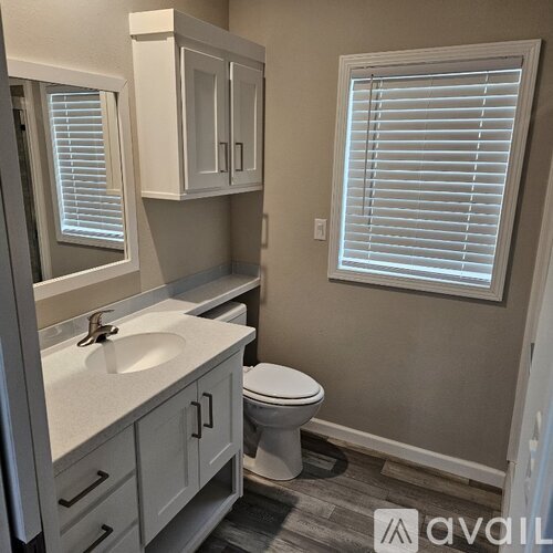 A bathroom with a toilet, sink, and bathtub.