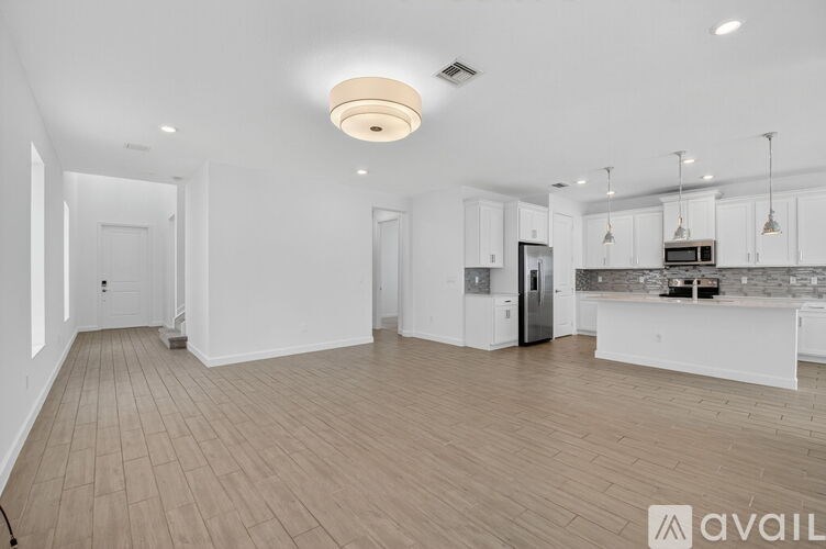 A spacious kitchen with white cabinets and a central island.